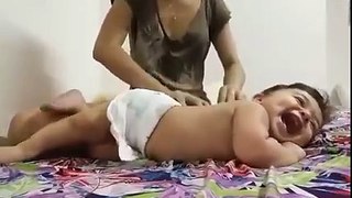Baby enjoying massage from his mother