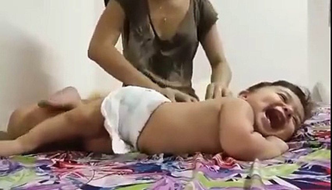 Baby enjoying massage from his mother