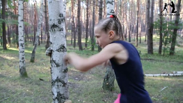 Une jeune boxeuse enchaîne les coups contre un arbre