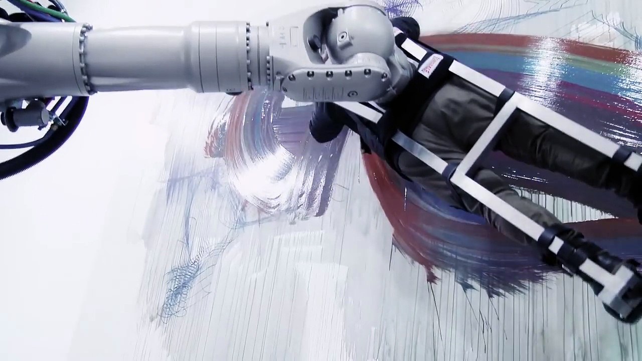 Un homme sert de pinceau pour un immense robot