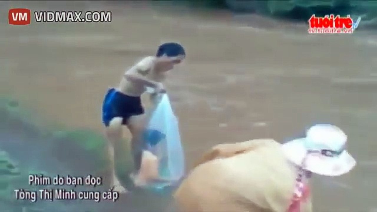 Dad puts daughter in plastic bag to cross a river.