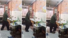 Dono de cabeleireiro para animais é visto a cantar e a dançar com cãozinho enquanto lhe dá banho