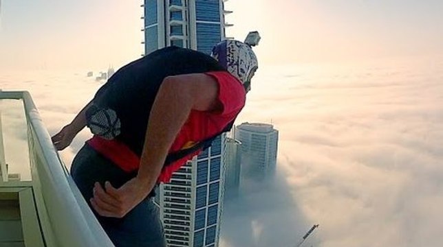 Un base jumper saute sans visibilité d'un gratte ciel au dessus des nuages !
