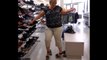 La femme de Régis essaye de porter des talons hauts dans un magasin
