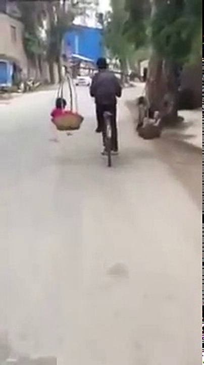 Người cha "vi diệu" vừa gánh con trên vai vừa chạy xe đạp