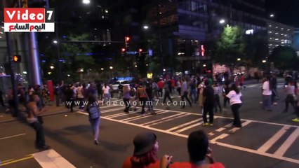 متظاهرون يكتبون شعارات غاضبة على سيارة للشرطة