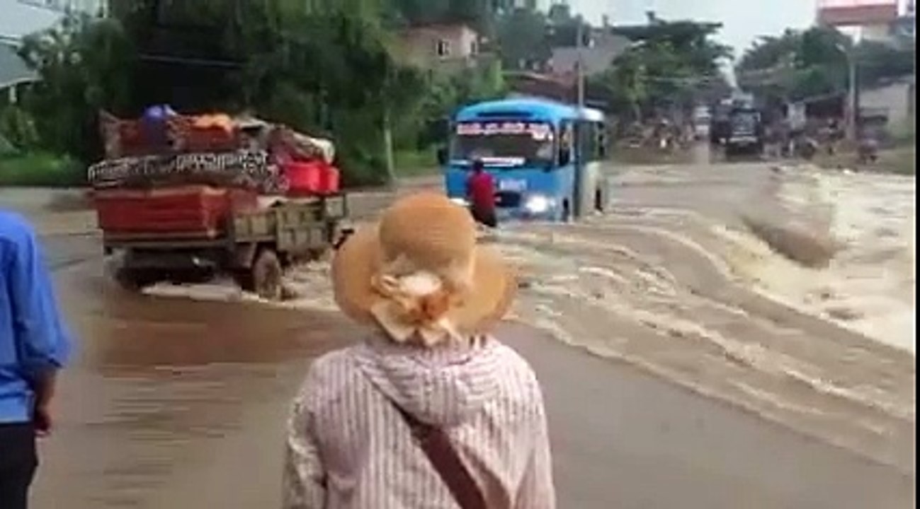 Hành khách phụ tài xế đẩy xe vượt lũ