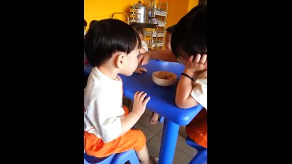 bé gái đút cho bé trai ăn