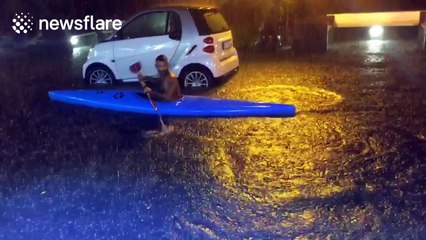 Man canoes on the flooded streets of Ischia, Italy