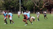 Un rugbyman fait un salto arrière pour éviter un plaquage