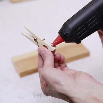 Elle en ligne 3 pinces à linge sur un bout de bois, et en colle 2 autres ensemble. Ce qu'elle fait par la suite est tout simplement BRILLANT!