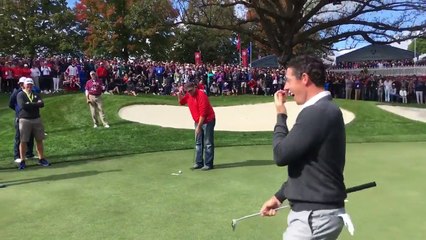 Un spectateur aide Rory McIlroy à terminer un putt au golf
