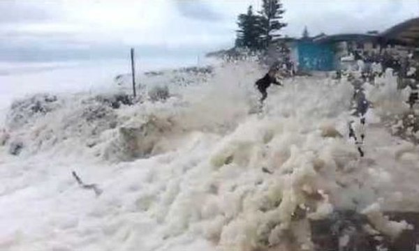 Une tempête de mousse de mer recouvre toute une plage, sa route et son parking en Australie