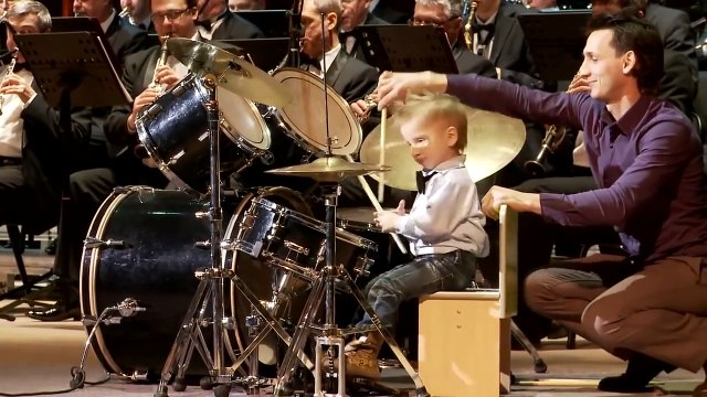 Ce gamin de 3 ans mène le rythme dans cet orchestre d'adulte! Futur génie de la batterie