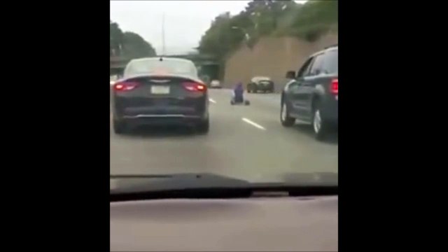 Rouler en tricycle sur l'autoroute entre les voitures... Le fou !