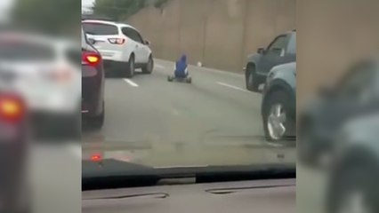 Il roule en tricycle sur une route très fréquentée