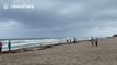 People gather on Florida beach to film and photograph approaching hurricane