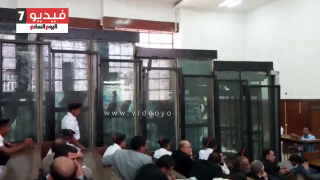 بديع ومتهمى فض رابعة يرفعون لافتات بالقفص عن مرسى