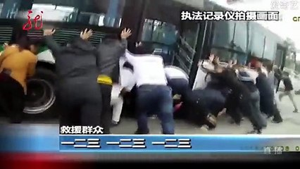 Passersby push over a bus to rescue an elderly lady under it