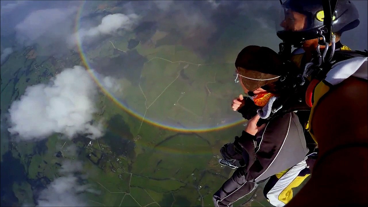 Des parachutistes sautent au dessus d'un arc-en-ciel visible à 360°