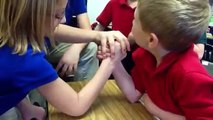 A girl beats a boy In arm-wrestling