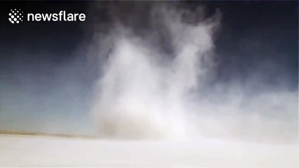 Huge dust devil swirls across riverside