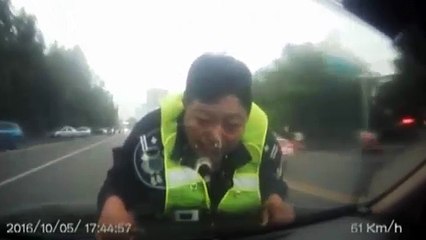 Un individu ivre conduit avec un policier sur son capot.