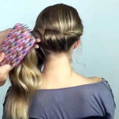 Il retient une grosse mèche de cheveux sur le côté et la tourne sur elle-même quelques fois! Sa coiffure est magnifique!