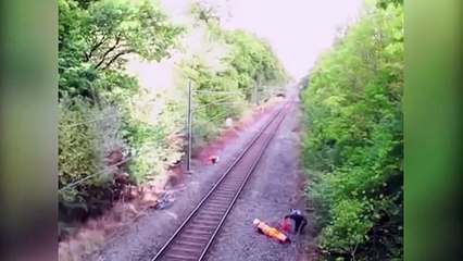 Heroic rail worker risks life to save 'drunk' cyclist about to be hit by train in incredible CCTV