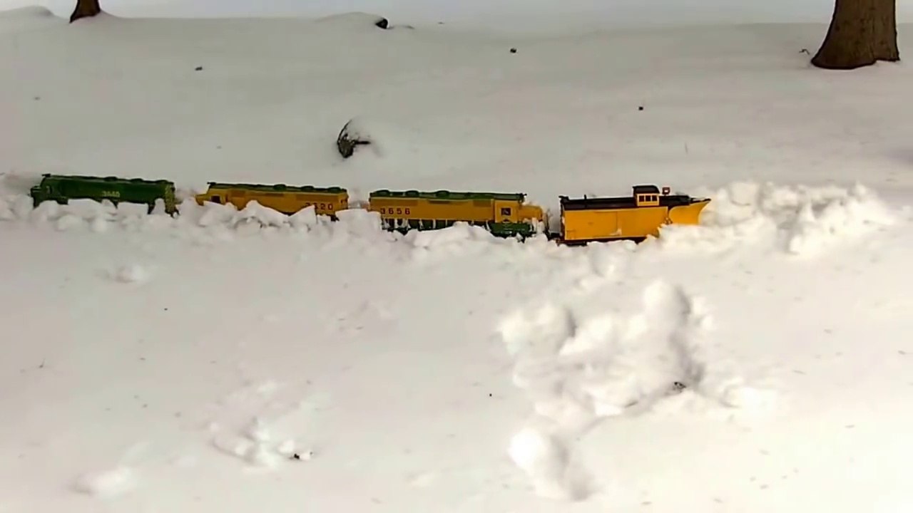 Un train miniature roule dans la neige dans le jardin !