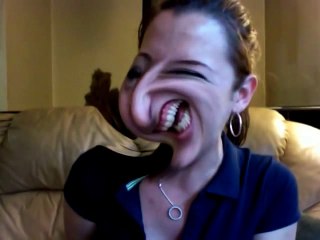 Girl laughing while making funny faces on distorted webcam