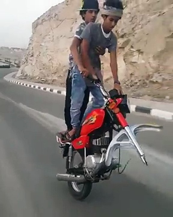 Deux jeunes roulent en moto sans la roue avant