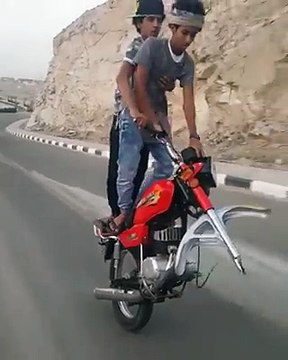 Deux jeunes roulent en moto sans la roue avant