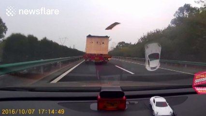 Debris flies out of trailer and smashes windscreen of car behind