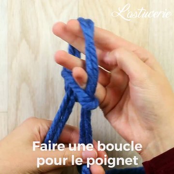 Elle commence par enrouler deux fils de laine autour de son poignet... Sans aiguilles, elle tricote la plus belle des écharpes!