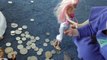 Barbies find money coins to play with. Ken Barbie and baby have a pile of silver dollars