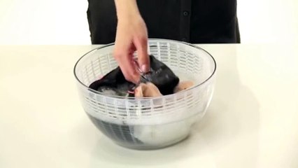 She puts the clothes in the centrifuge for salad.