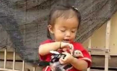 Une petite fille lave avec soin un oiseau.