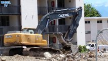 Deere 270D excavator separating debris from a torn down building
