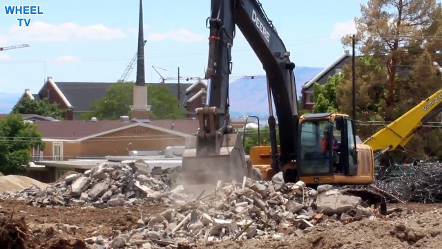 Deere Excavator moving concrete and rebar debris around from a torn down building