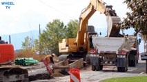 DEERE loader and Excavator working a road construction site filling a big rig dump truck