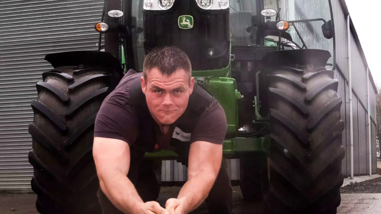 il déplace un tracteur à main nue