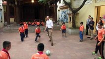 Prince William plays football and high fives Vietnamese children