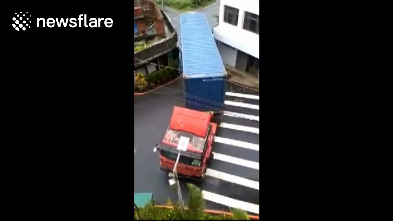 Lorry squeezes through narrow gap between houses