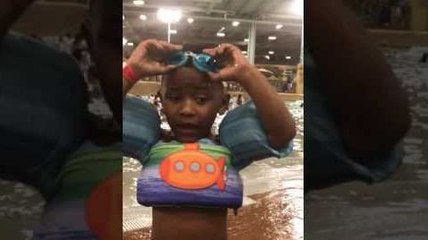 Un petit garçon cherche ses lunettes de piscine