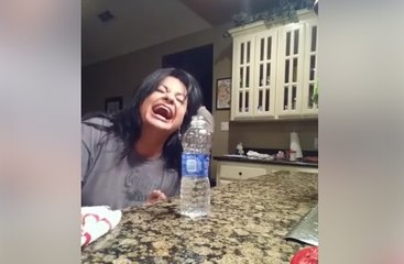 Une femme montre un étonnant tour de magie à son mari avec une bouteille d'eau
