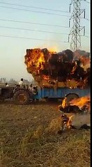 A Tractor with grass catches fire