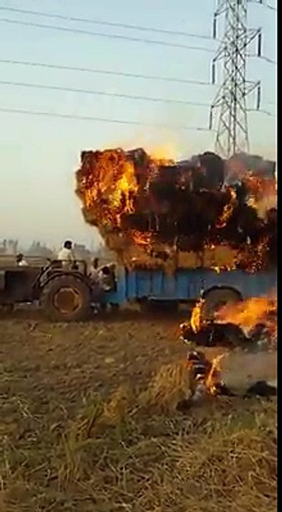 A Tractor with grass catches fire
