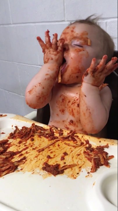 Un bébé à moitié endormi mange des pâtes bolognaise  !