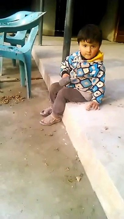cute baby cutting walnut with hammer. very funny to watch